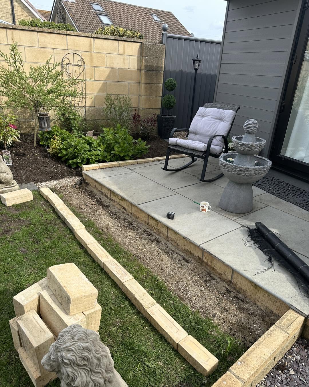 Patio laid beside a garden room with new planted border and sleeper edging