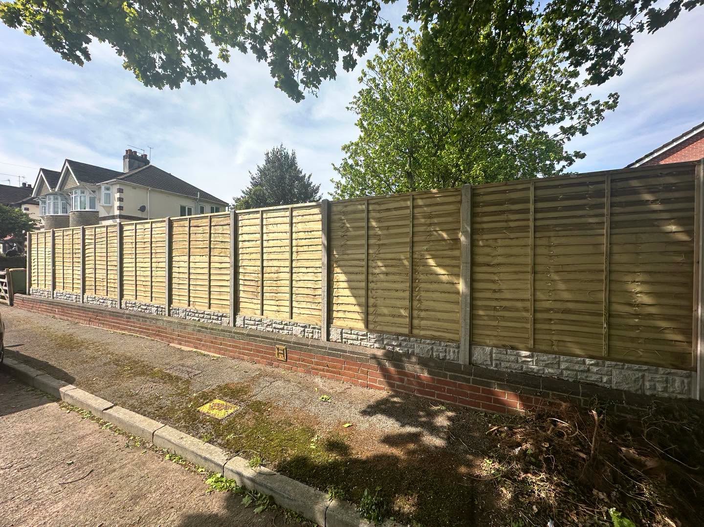 Close-board timber fencing with concrete posts and gravel boards