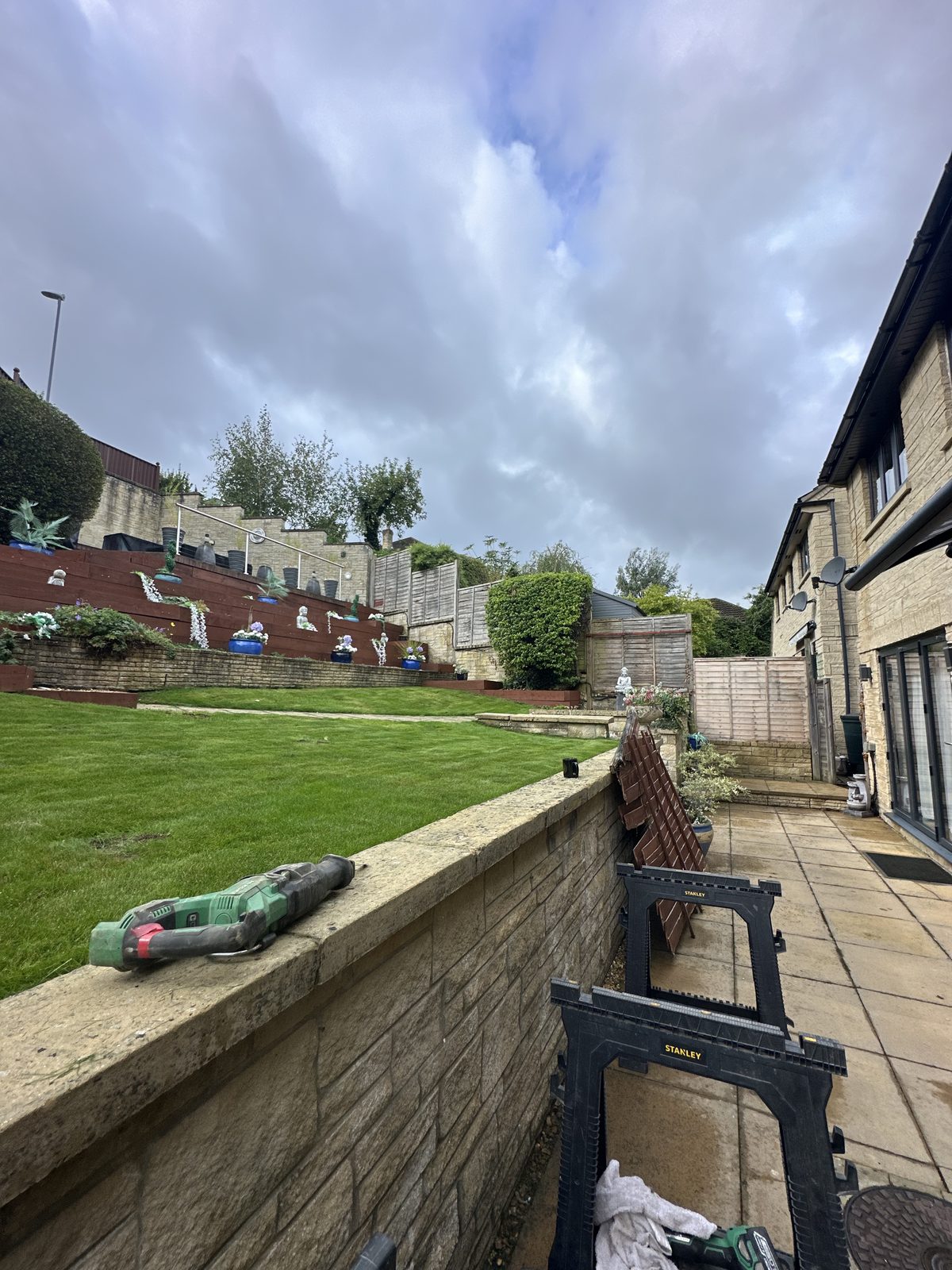 Before: a tired boundary above a tiered, stone-walled garden