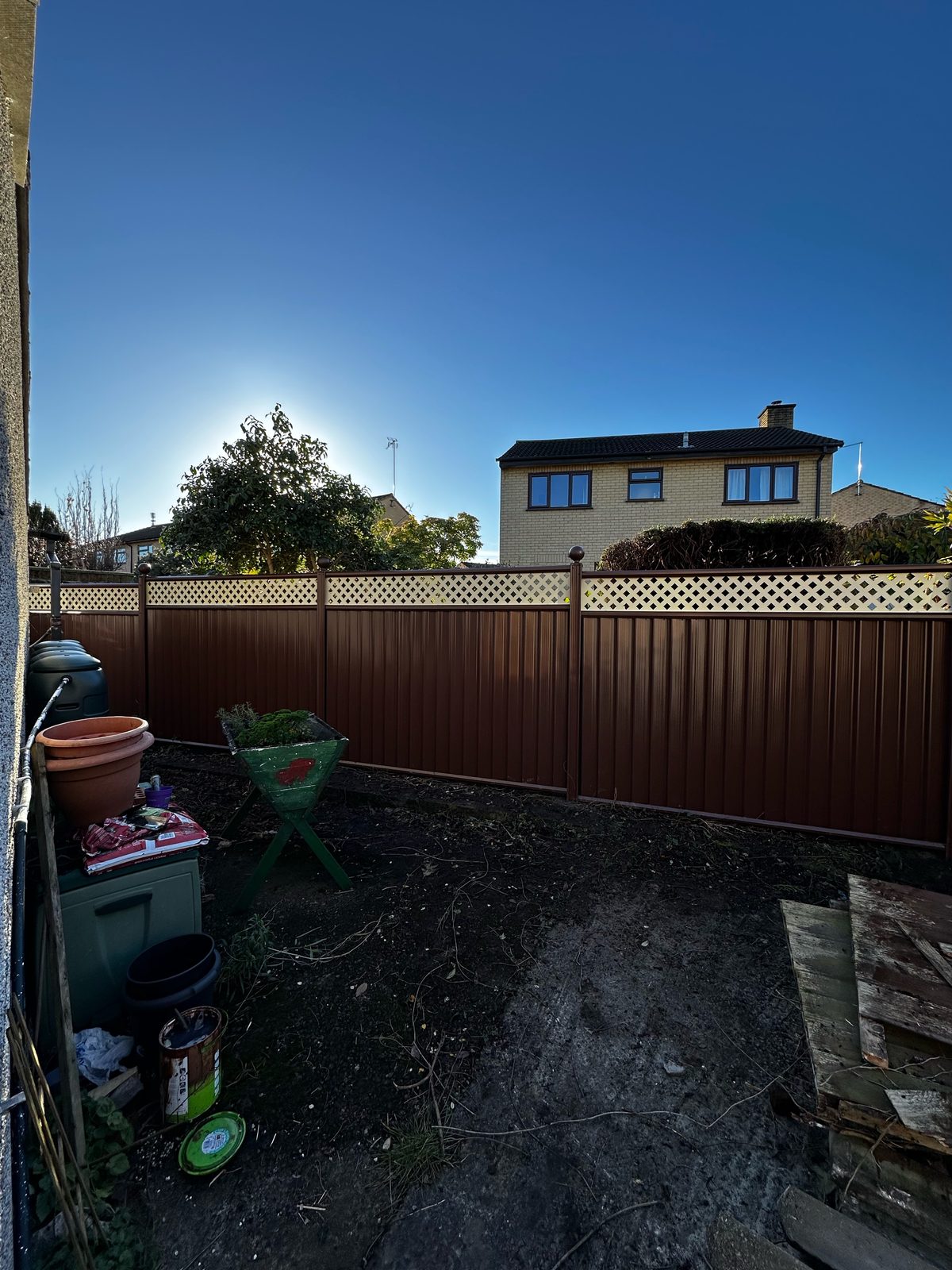 After: brown metal fencing manufactured from Colorbond steel with a decorative lattice top