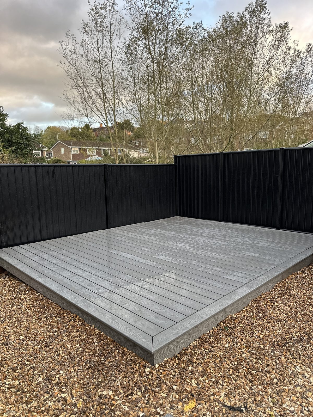 After: new grey composite decking with black metal fencing manufactured from Colorbond steel