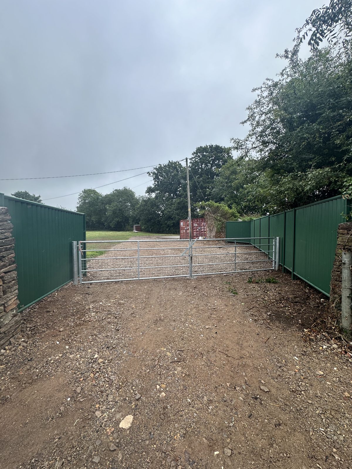 After: green metal fencing manufactured from Colorbond steel beside a galvanised gate