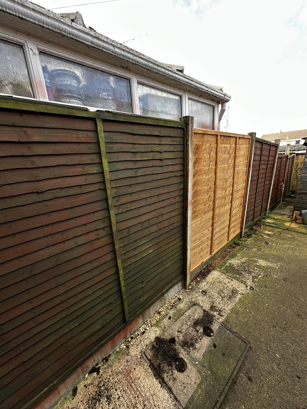 Before: weathered timber lap fence panels at the end of their life