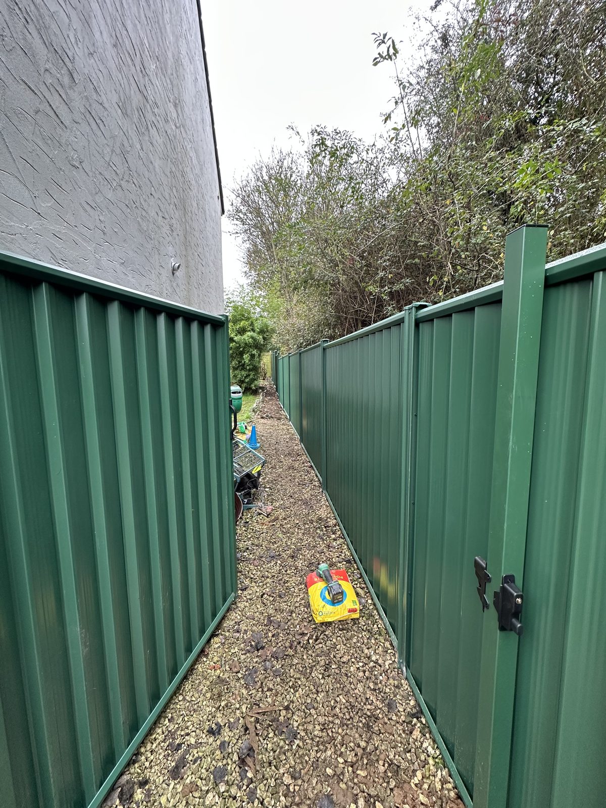 After: green metal fencing manufactured from Colorbond steel down the side passage