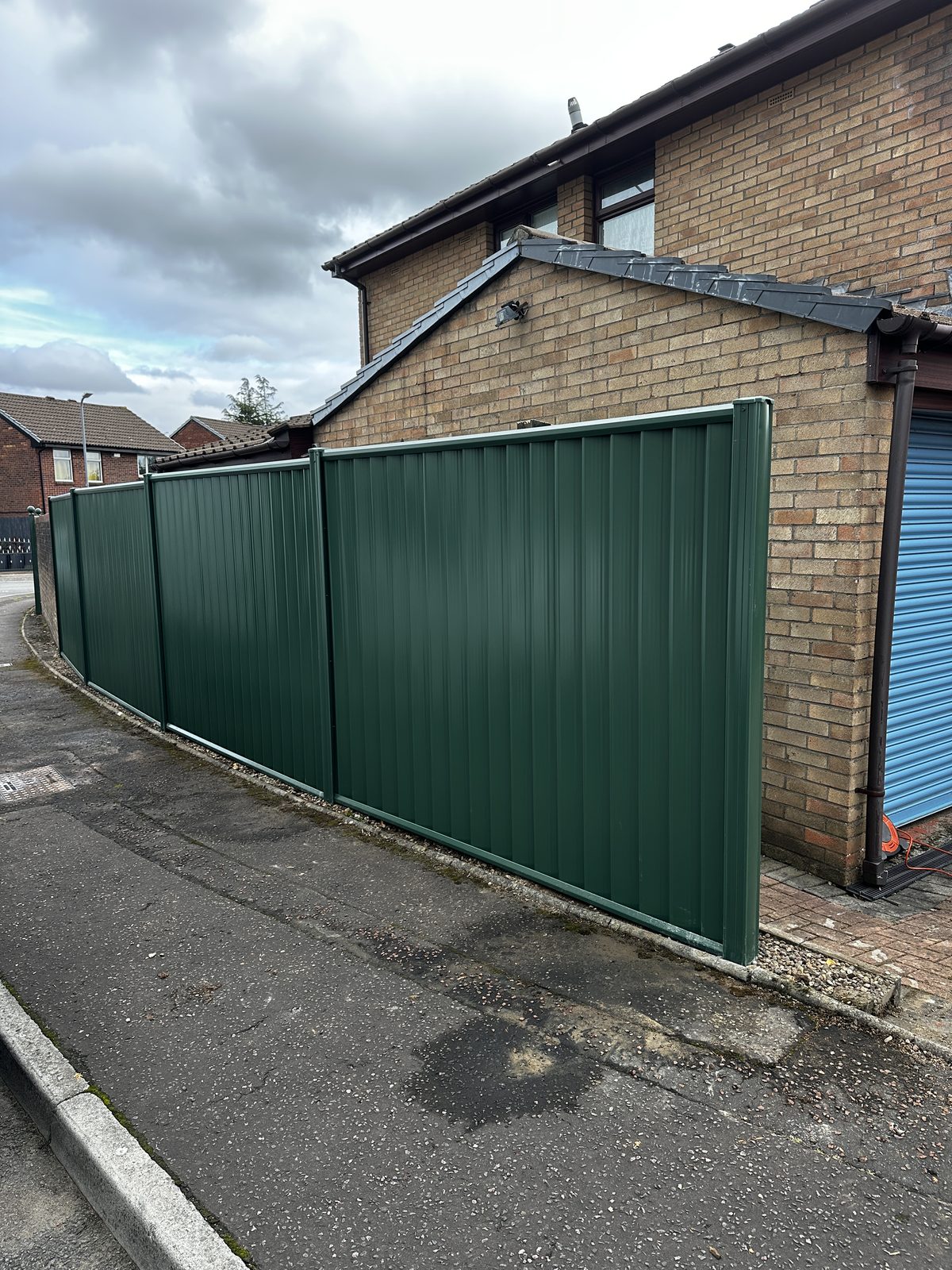 After: green metal fencing manufactured from Colorbond steel along the roadside