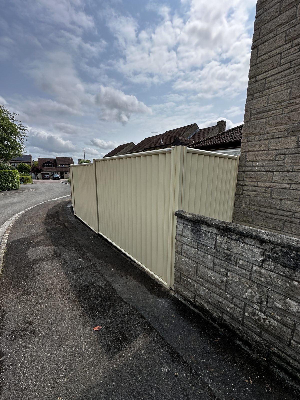 Cream metal fencing running neatly along a side passage