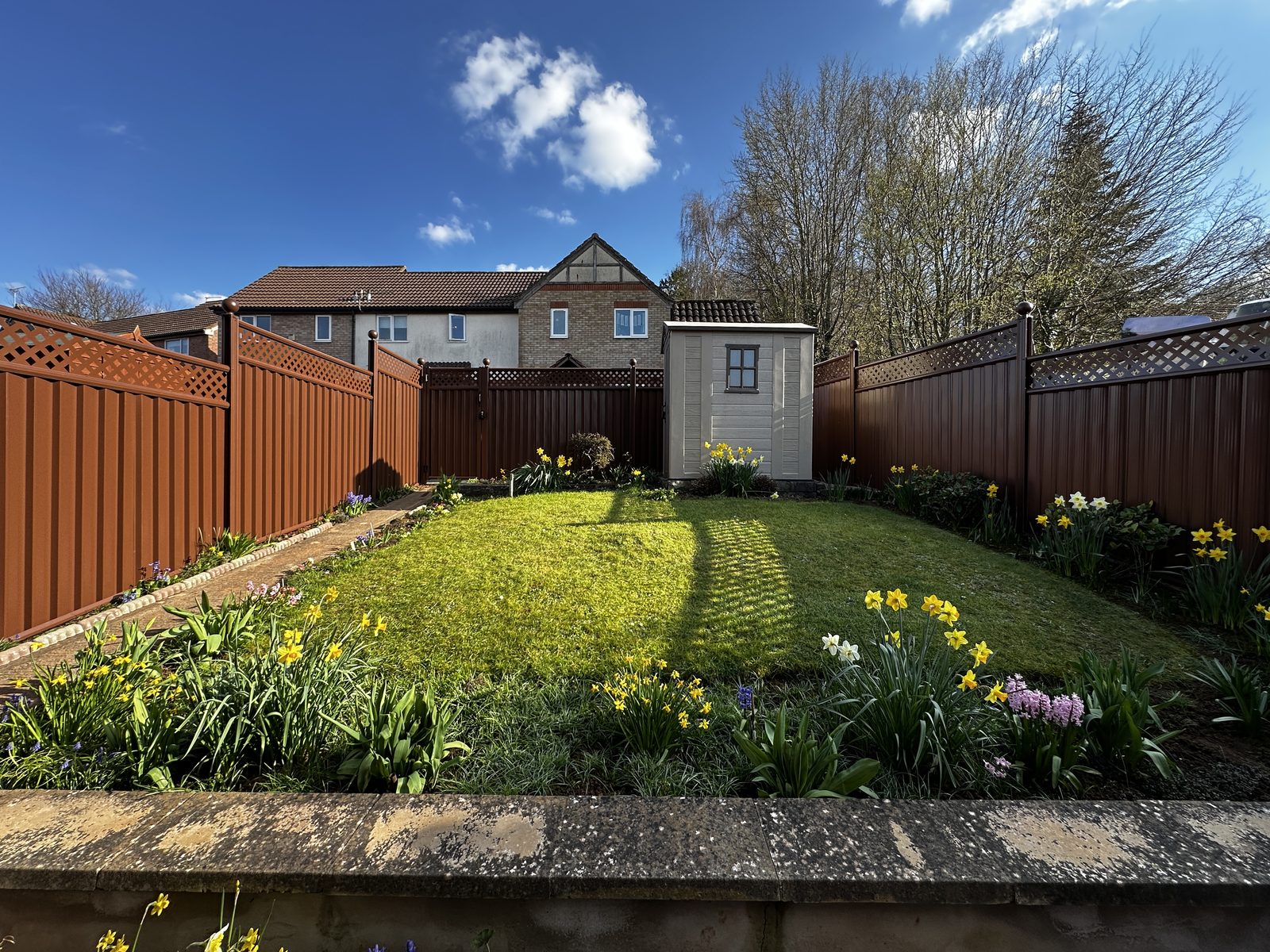 Anthracite and timber fencing around a wide lawned garden