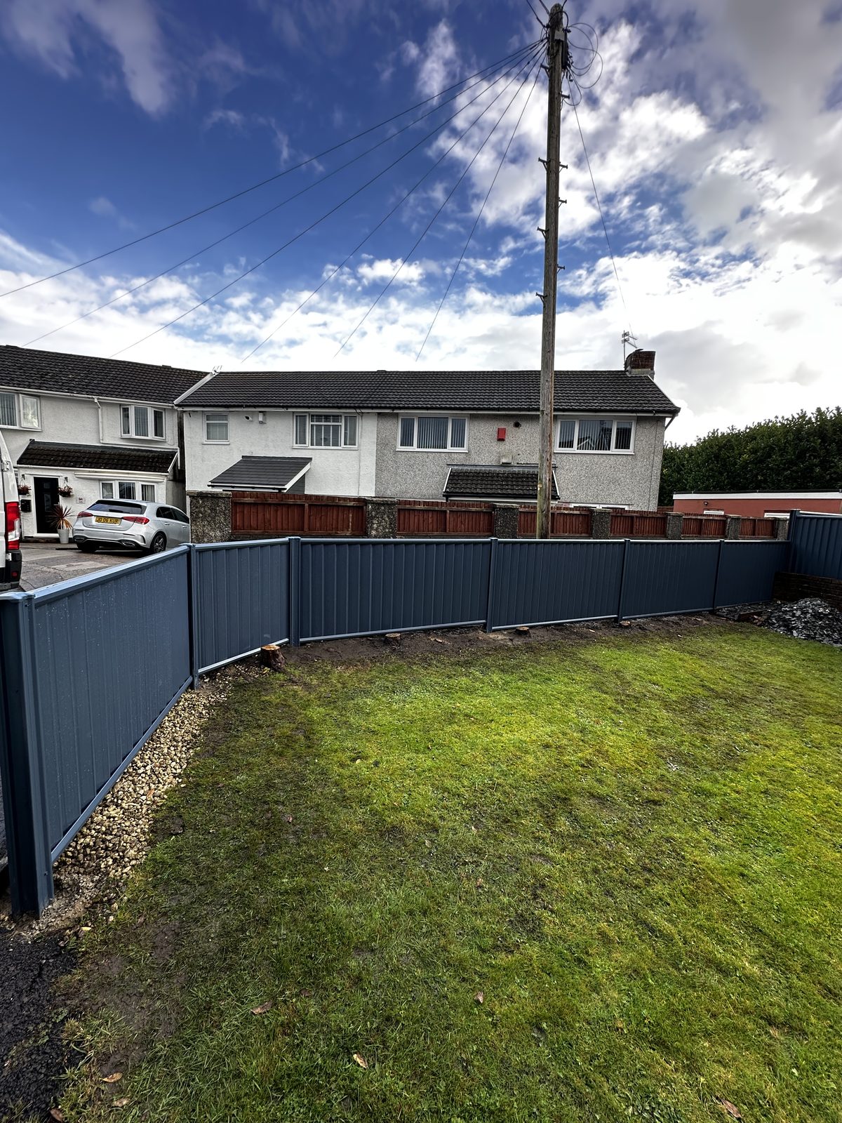 Anthracite metal fencing along a back garden lawn
