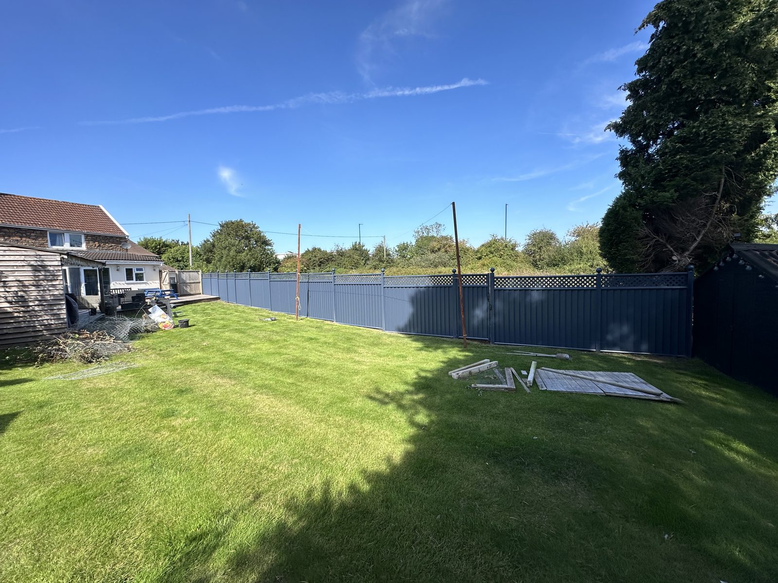 Navy metal fencing manufactured from Colorbond steel with a slatted top running the length of a garden
