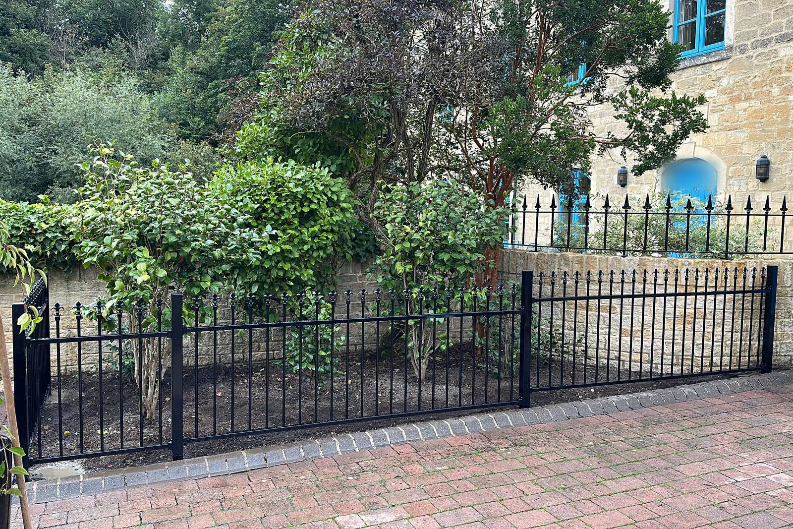 Black metal railings with a matching frontage gate.