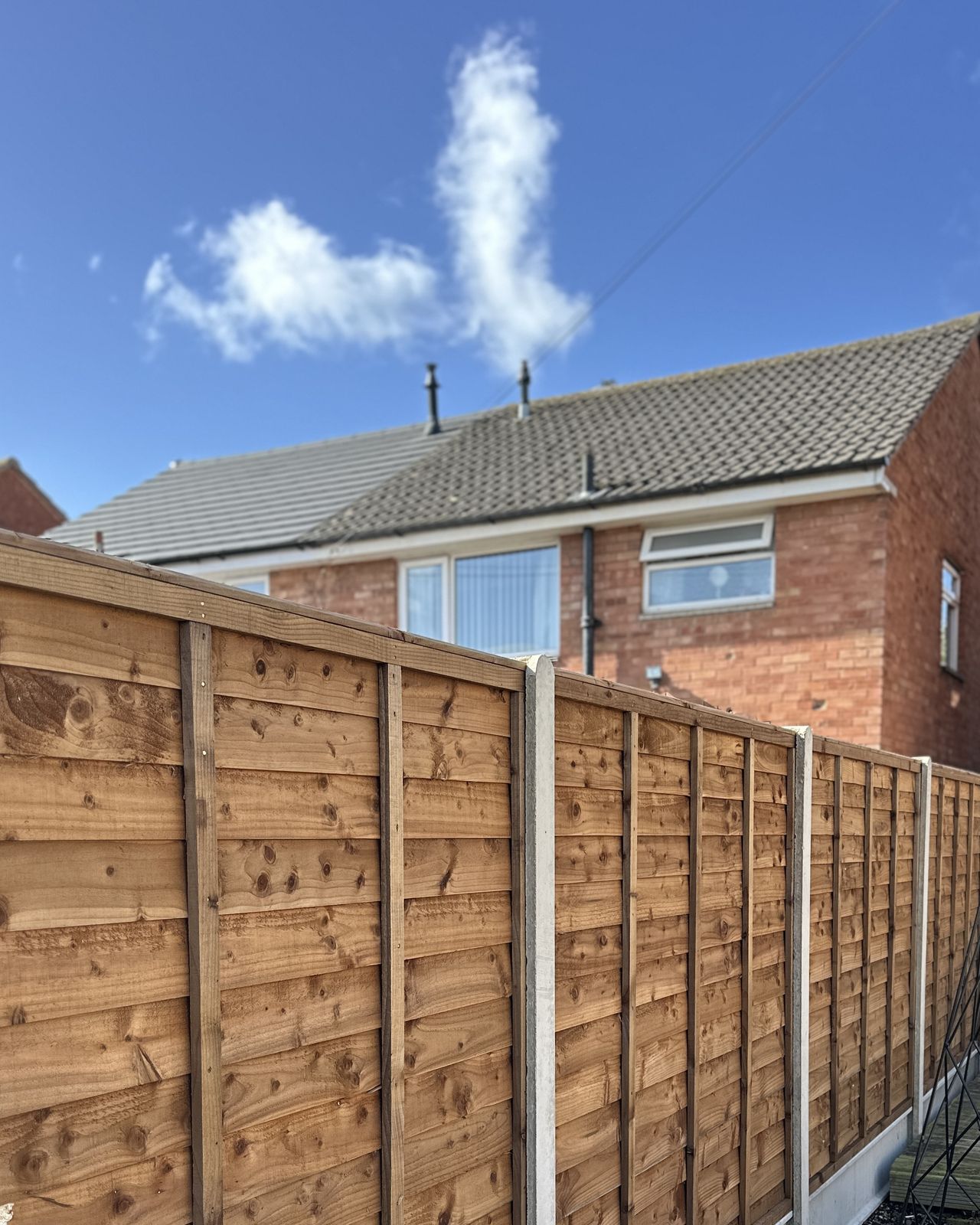 Brown timber fence panels forming a garden boundary.