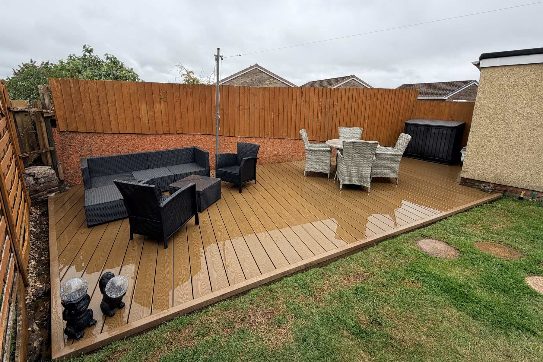 Teak composite decking with freestanding garden furniture.