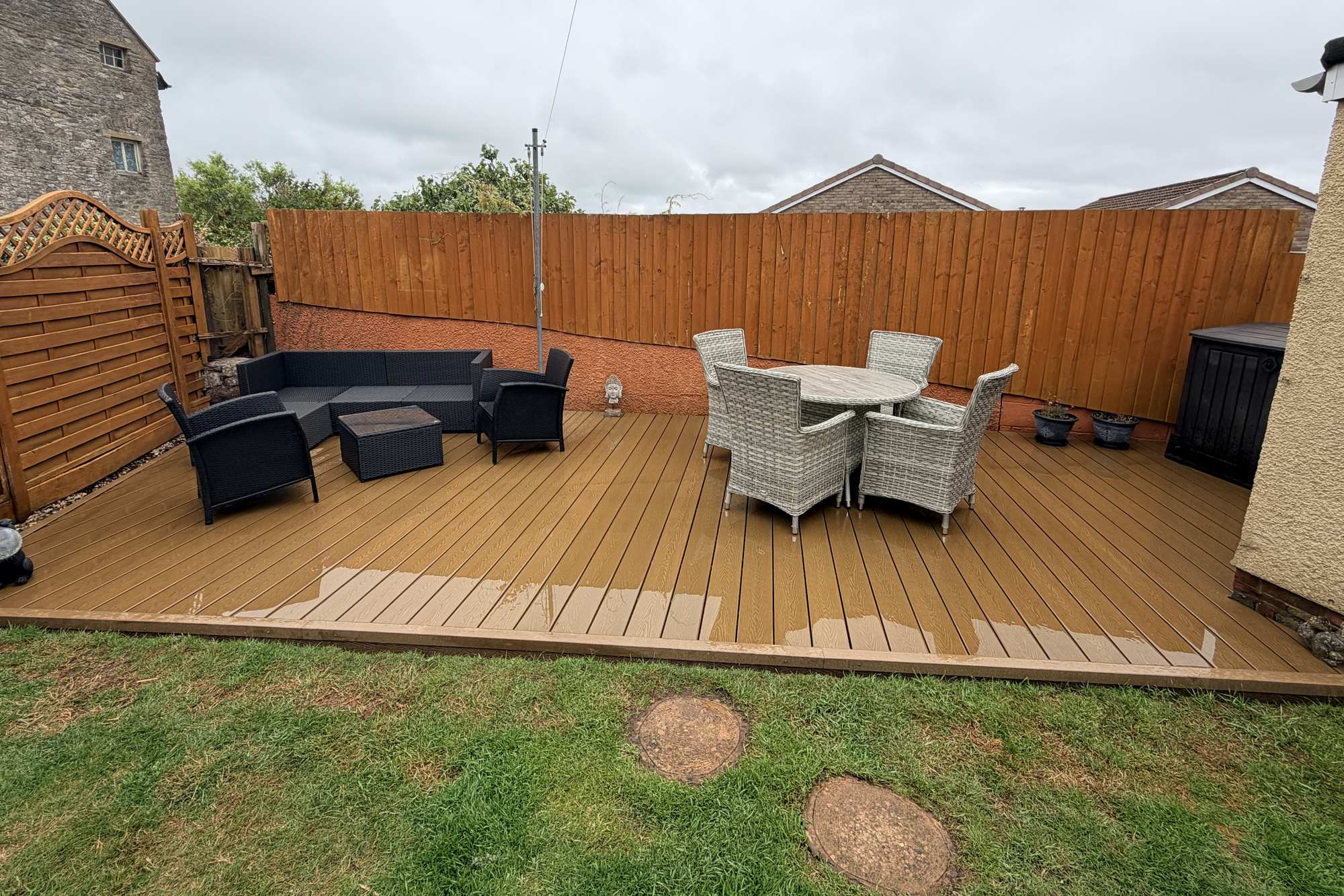Teak composite decking with freestanding garden furniture.