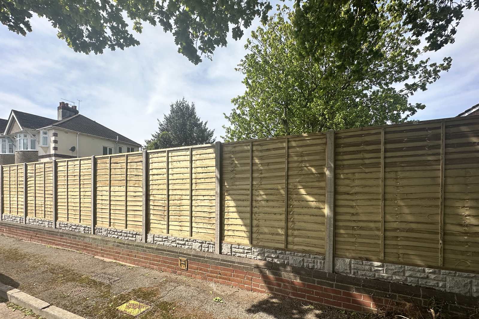 Finished timber fencing beside established planting.