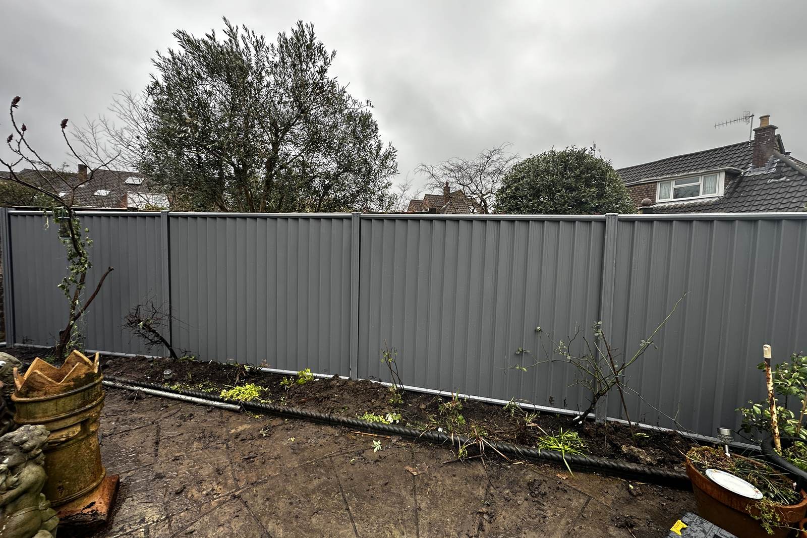 Grey metal fencing system installed along the boundary.