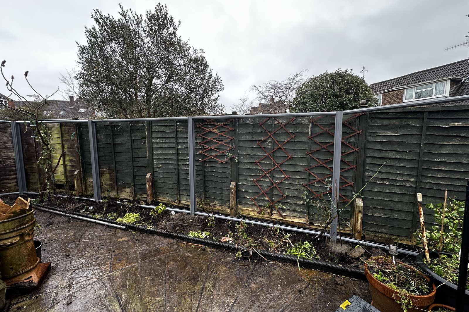 Failing timber fence panels before replacement.