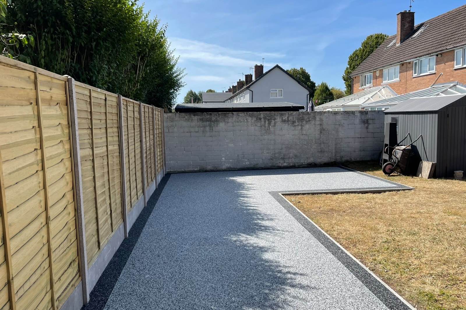 Resin-bound garden paths and seating areas alongside timber fencing on concrete posts.