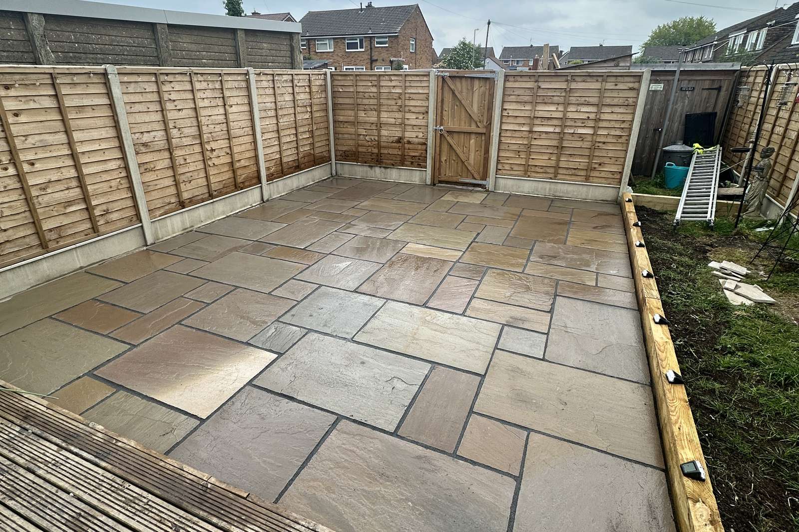Completed sandstone patio filling the garden area.
